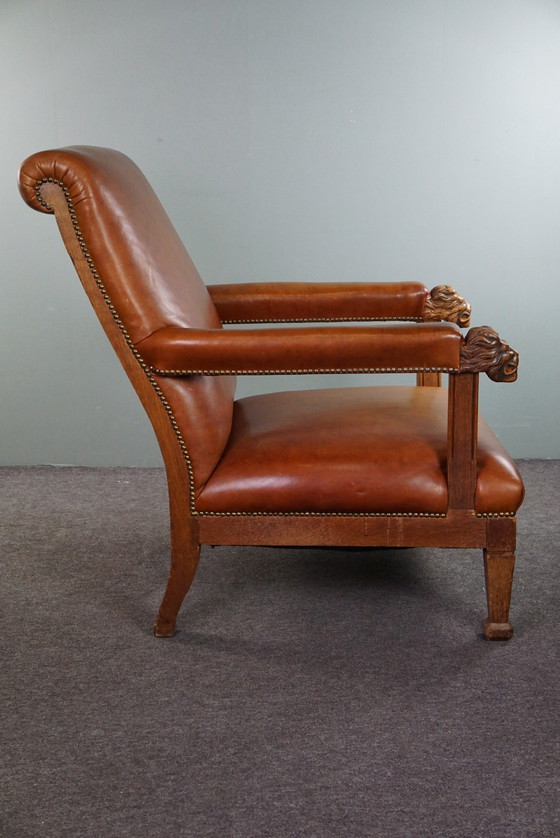 Image 1 of Fauteuil met leeuwenkoppen opnieuw bekleed met cognac kleurig rundleer