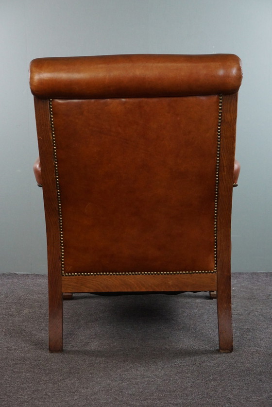 Image 1 of Fauteuil met leeuwenkoppen opnieuw bekleed met cognac kleurig rundleer