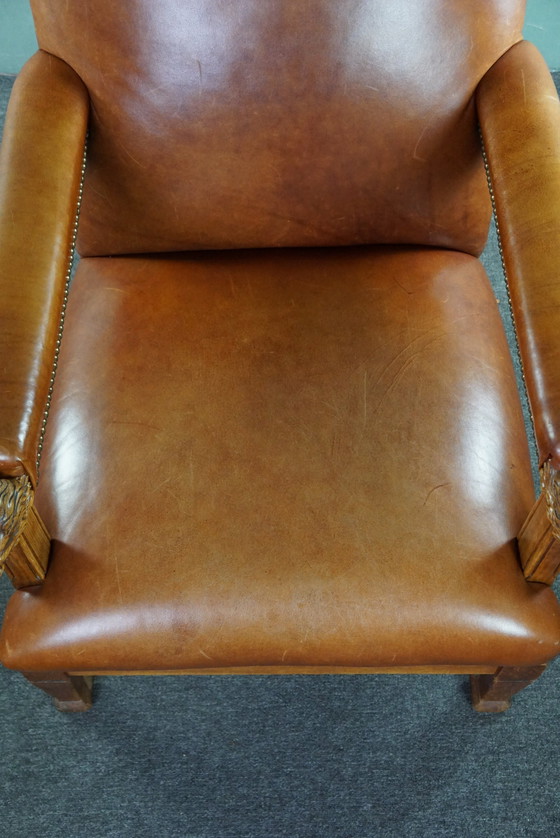 Image 1 of Fauteuil met leeuwenkoppen opnieuw bekleed met cognac kleurig rundleer