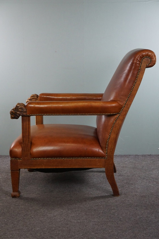 Image 1 of Fauteuil met leeuwenkoppen opnieuw bekleed met cognac kleurig rundleer