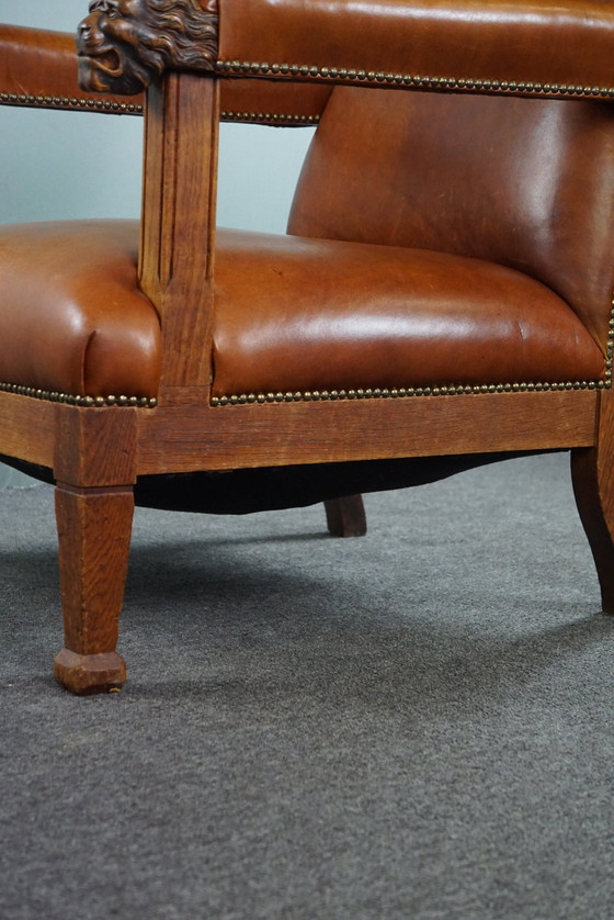 Image 1 of Fauteuil met leeuwenkoppen opnieuw bekleed met cognac kleurig rundleer