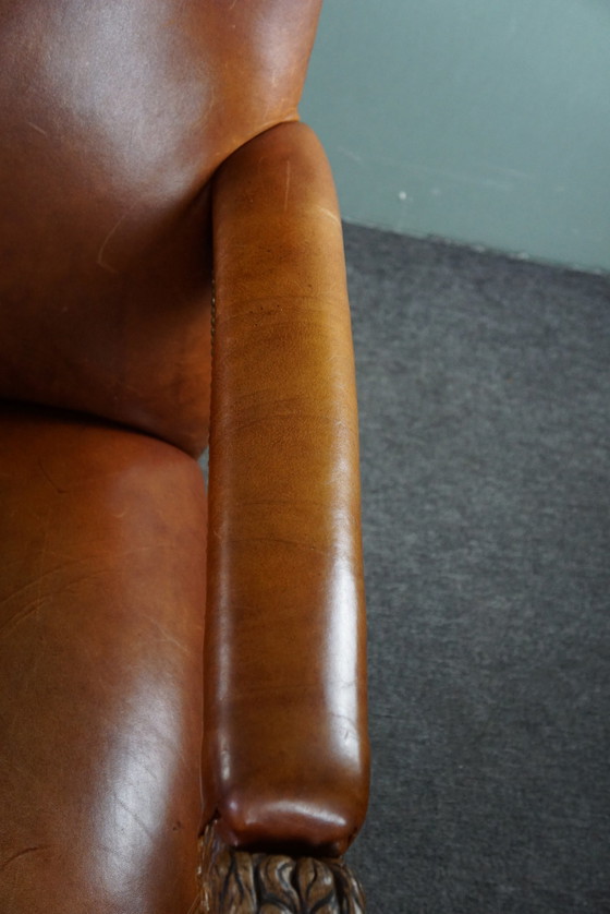 Image 1 of Fauteuil met leeuwenkoppen opnieuw bekleed met cognac kleurig rundleer