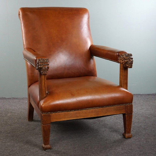 Fauteuil met leeuwenkoppen opnieuw bekleed met cognac kleurig rundleer