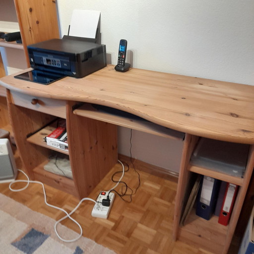 Een houten computerbureau met planken en een uitschuifbaar toetsenbordblad