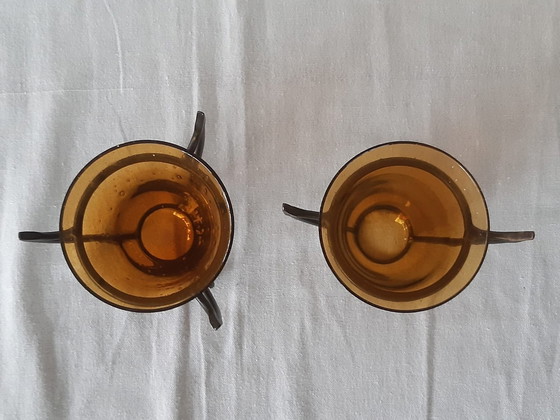 Image 1 of Twee Vintage Hysteria Vaasjes Uit Amberkleurig Glas In Metalen Houders