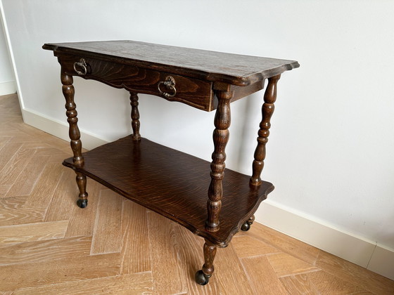 Image 1 of Vintage gesneden eikenhouten haltafel op wielen met een lade