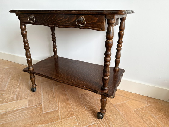 Image 1 of Vintage gesneden eikenhouten haltafel op wielen met een lade