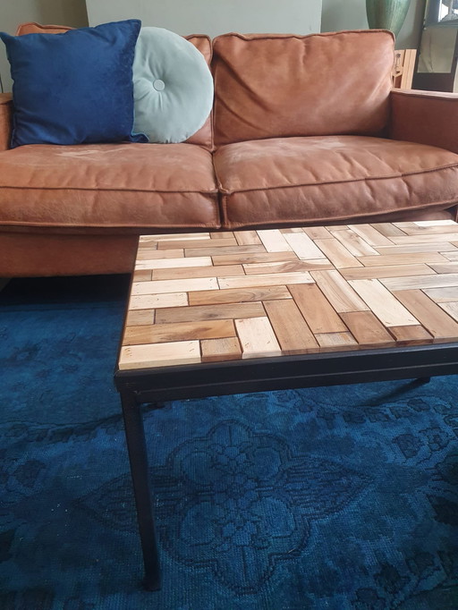 Salontafel Met Zwart Metalen Frame En Ingelegd Met Hergebruikt Hout In Een Speels Motief