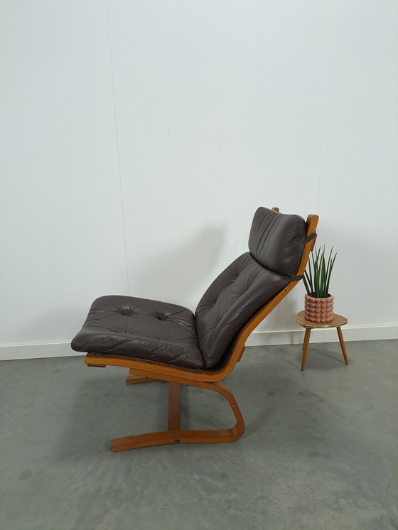 Image 1 of Bruin leren fauteuil met houten onderstel