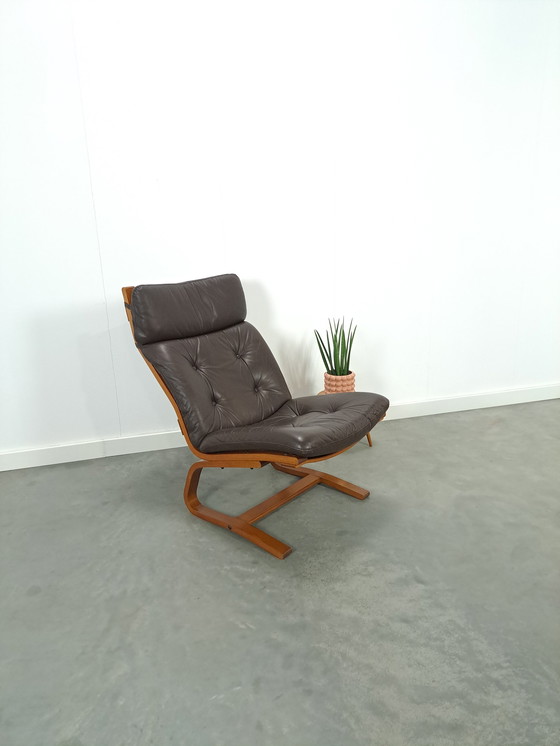 Image 1 of Bruin leren fauteuil met houten onderstel