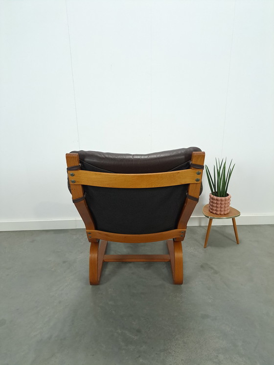 Image 1 of Bruin leren fauteuil met houten onderstel