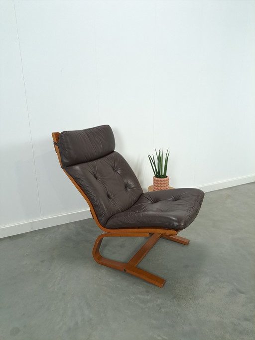 Bruin leren fauteuil met houten onderstel