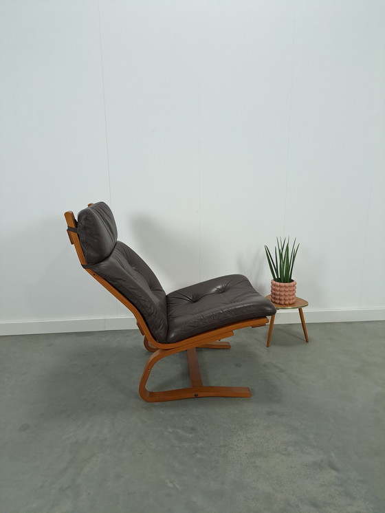 Image 1 of Bruin leren fauteuil met houten onderstel