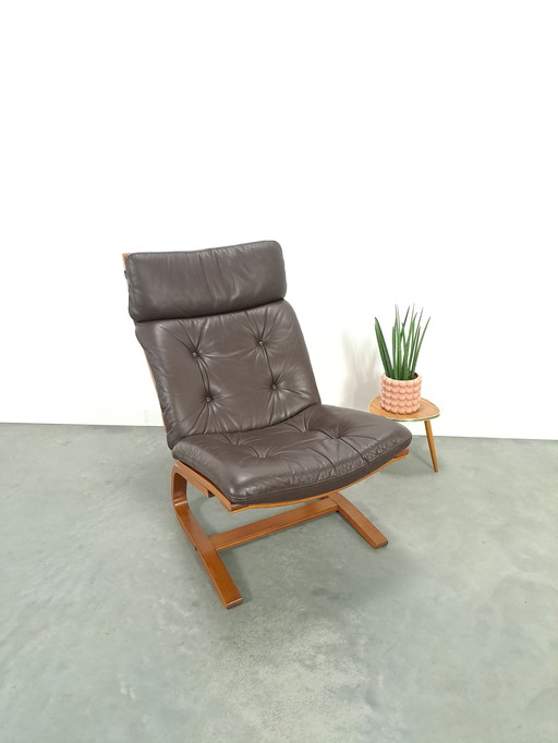 Bruin leren fauteuil met houten onderstel