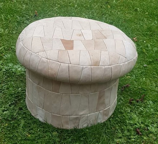 Poef met patchworklederen bekleding en een opbergvak aan de binnenkant.