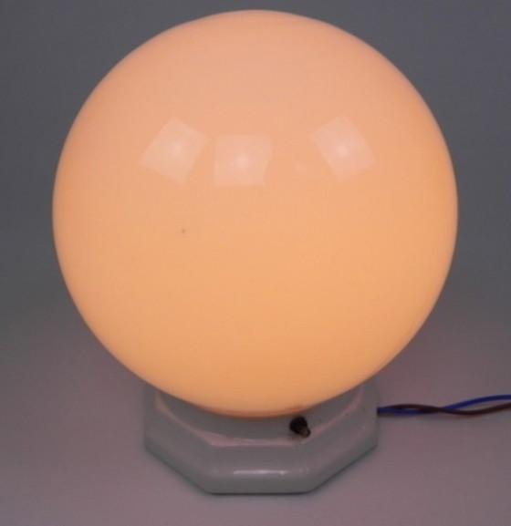 Image 1 of Art deco plafondlamp met ronde glazen bol en porseleinen armatuur