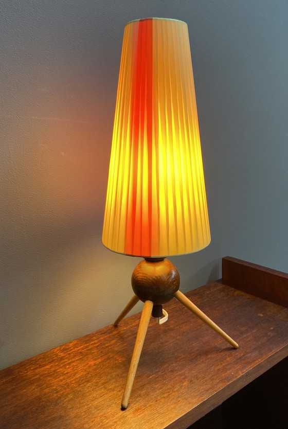 Image 1 of Tafellamp met geel en rood lint, houten driepoot 1950S