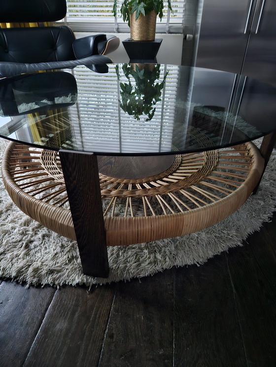Image 1 of Ronde Salontafel...Diameter 105 Cm...Hoogte 40 Cm..Gefumeerd Glas.Grijs...Houten Poten..Riet Vlechtwerk