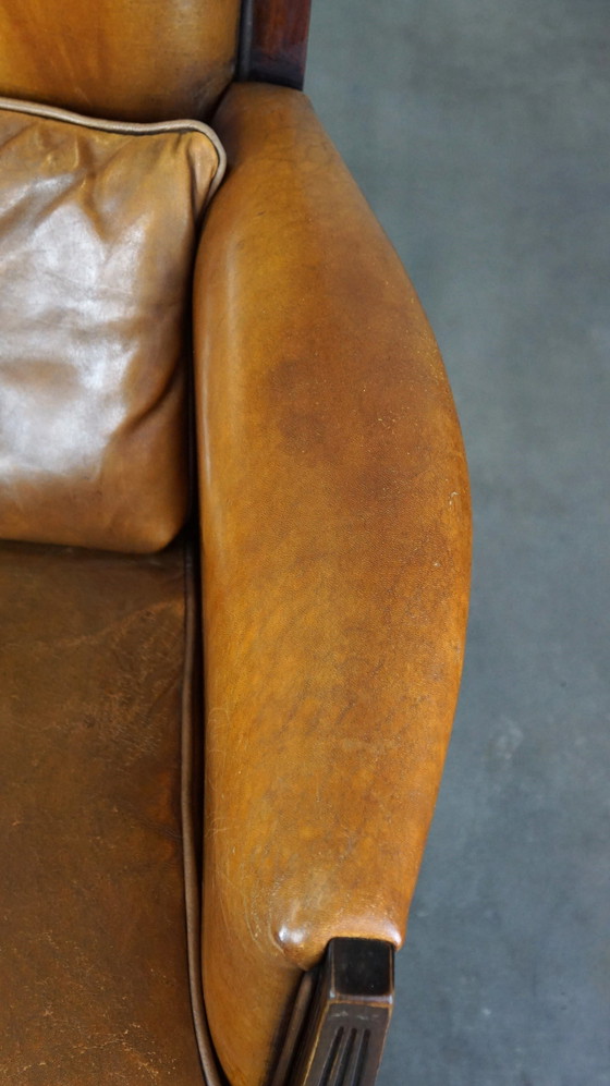 Image 1 of Vintage schapenleren design fauteuil met hoge rug en hout accenten