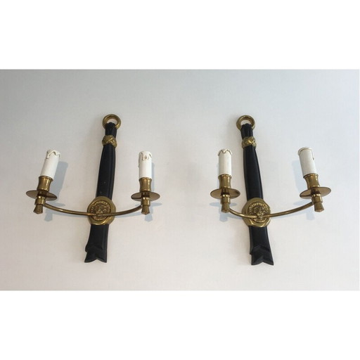 Paar zwart gelakte bronzen wandlampen met leeuwenkop decoraties.