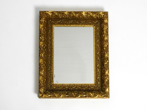 Mid Century wall mirror from Italy with an ornate, gold-plated wooden frame