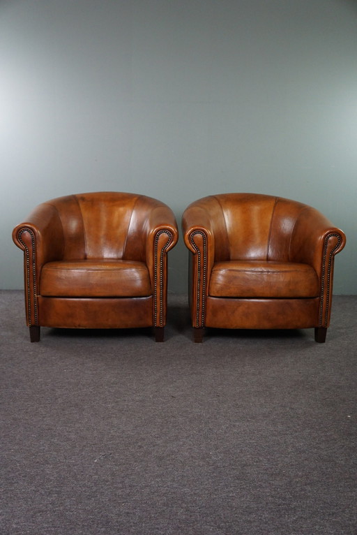 Set of two sheep leather club chairs with fixed cushions