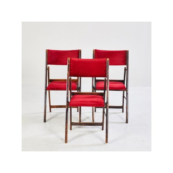 Image 1 of Silla plegable angular de mediados de siglo con estructura de madera y asiento y respaldo rojos.