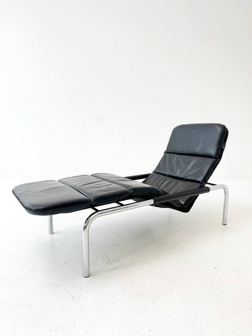 Designer lounger in black leather with tubular metal frame