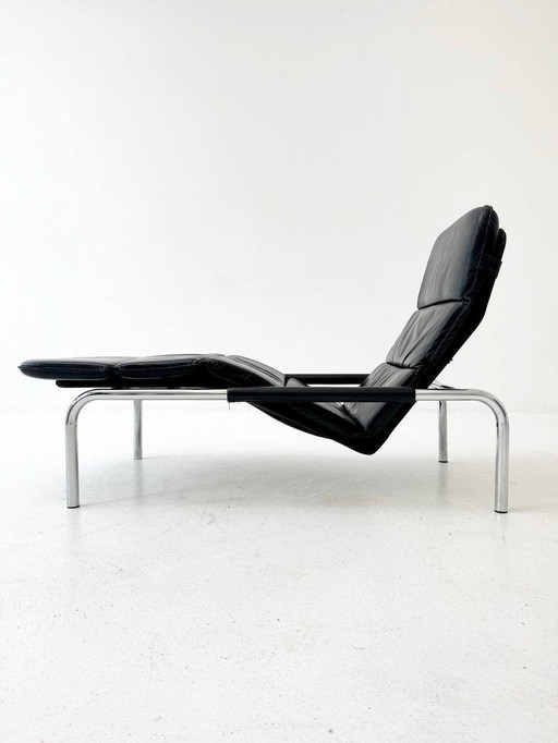 Designer lounger in black leather with tubular metal frame