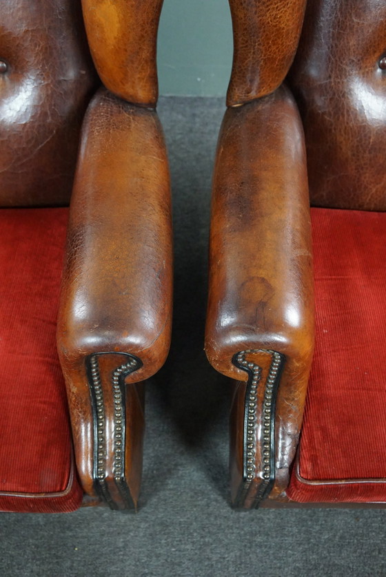 Image 1 of Ensemble de deux chaises à oreilles en cuir de mouton avec coussins d'assise en velours rouge