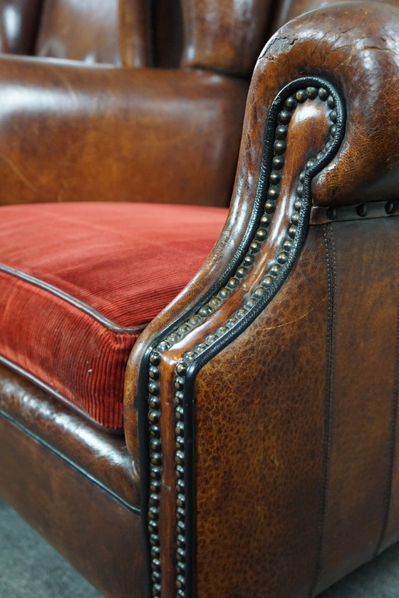 Image 1 of Ensemble de deux chaises à oreilles en cuir de mouton avec coussins d'assise en velours rouge