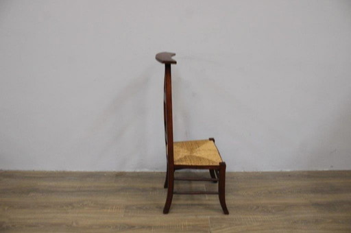 Silla de oración antigua con asiento de mimbre 