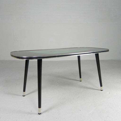 Table basse vintage avec plateau en verre et pieds angulaires et effilés. 1950s