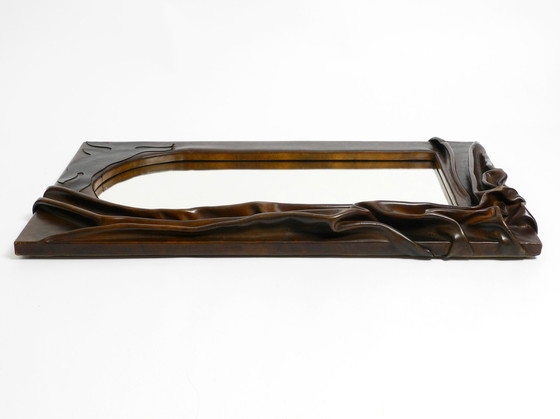 Image 1 of Large wooden wall mirror with an elaborate and thick flowing leather cover from the 1970s