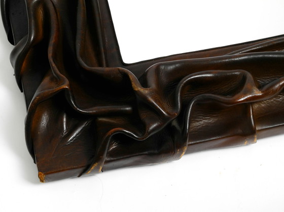 Image 1 of Large wooden wall mirror with an elaborate and thick flowing leather cover from the 1970s