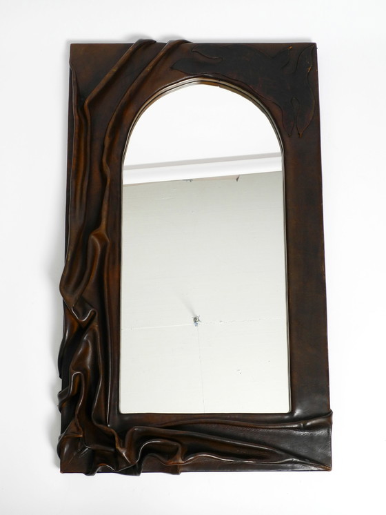 Image 1 of Large wooden wall mirror with an elaborate and thick flowing leather cover from the 1970s