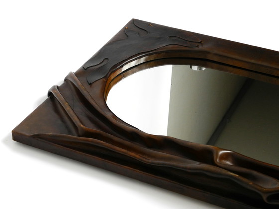 Image 1 of Large wooden wall mirror with an elaborate and thick flowing leather cover from the 1970s