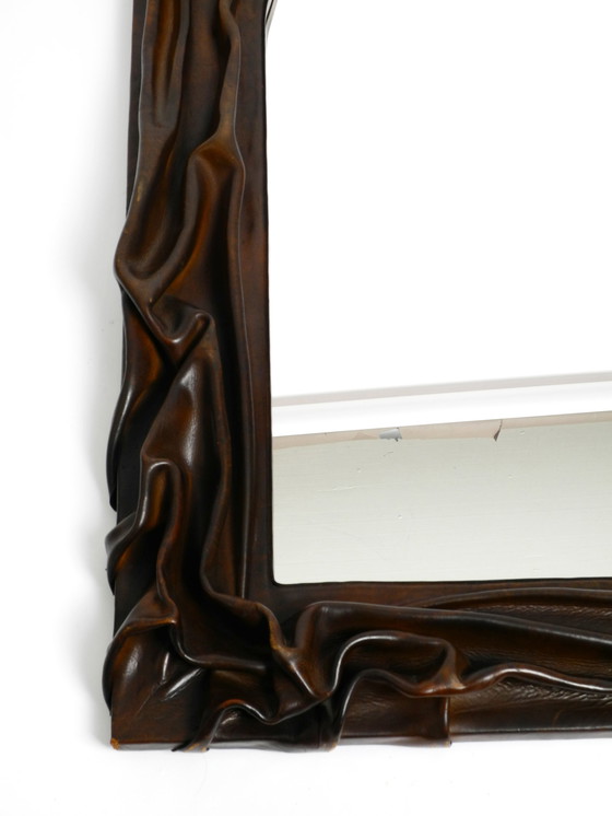 Image 1 of Large wooden wall mirror with an elaborate and thick flowing leather cover from the 1970s