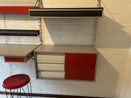 The Image Shows A Pilastro Wall Unit, A Design By Tjerk Reijenga From The 1950s, Against A Brick Wall.