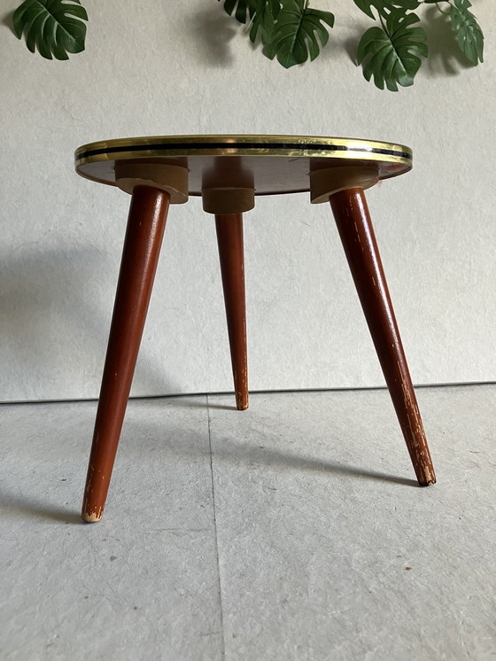 Image 1 of A Nice Vintage Plant Table From The 50s And 60s With Formica Top. Around the top is a strip in brass and black color.