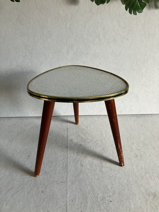 A Nice Vintage Plant Table From The 50s And 60s With Formica Top. Around the top is a strip in brass and black color.