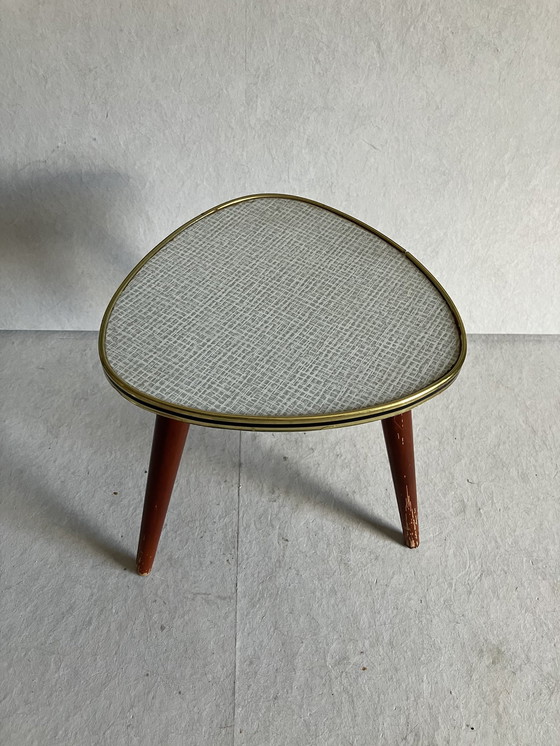 Image 1 of A Nice Vintage Plant Table From The 50s And 60s With Formica Top. Around the top is a strip in brass and black color.