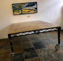 Mesa de trabajo de madera con estructura de metal, móvil y regulable en altura.