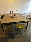 Mesa de trabajo de madera con estructura de metal, móvil y regulable en altura.