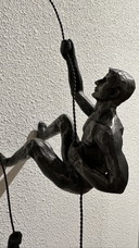 Homme grimpant suspendu à un fil
