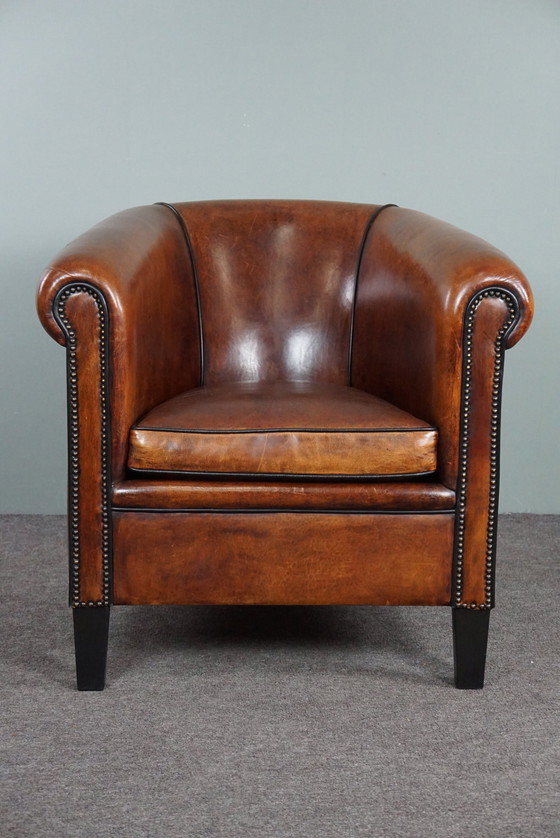 Image 1 of Fauteuil club en peau de mouton avec passepoil noir et rivets décoratifs