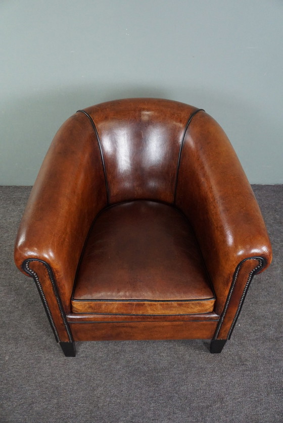 Image 1 of Fauteuil club en peau de mouton avec passepoil noir et rivets décoratifs