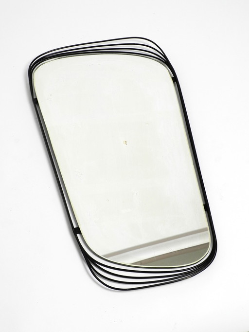 Mid Century Modern wall mirror with a black abstract metal frame