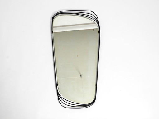 Mid Century Modern wall mirror with a black abstract metal frame