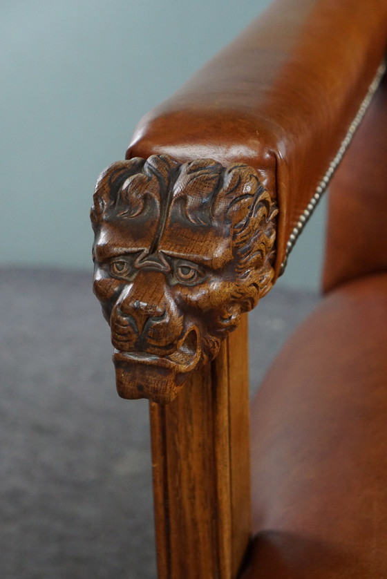 Image 1 of Armchair with lion heads reupholstered in cognac-colored cowhide leather